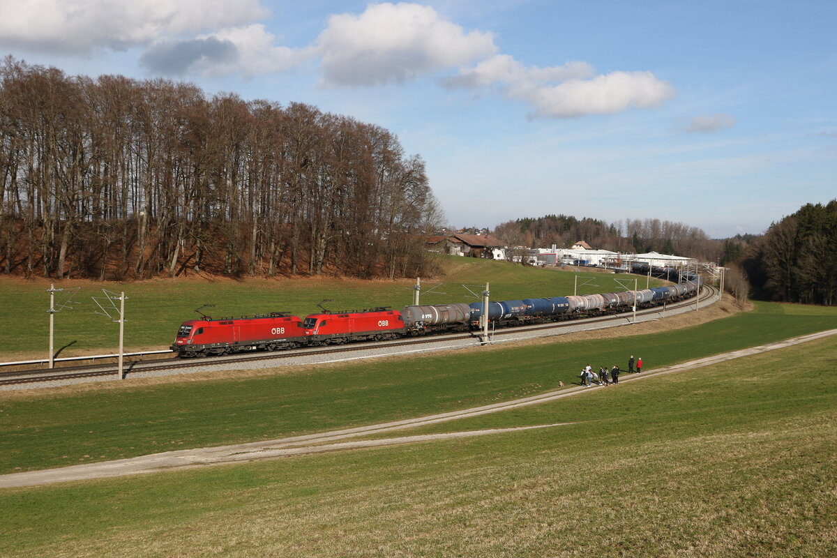 1116 046 und 1116 281 mit einem Kesselwagenzug aus Salzburg kommend am 18. Februar 2024 bei Axdorf im Chiemgau.