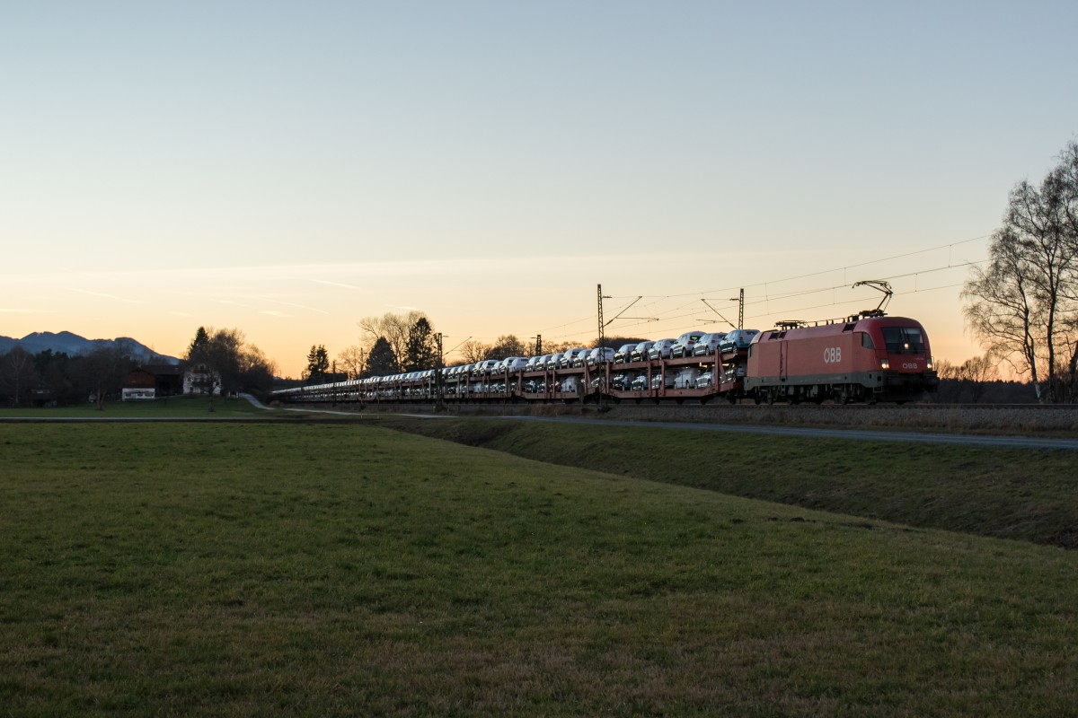 1116 163 mit einem Autozug im letzten Licht des 10. Dezember 2015 bei �bersee am Chiemsee.