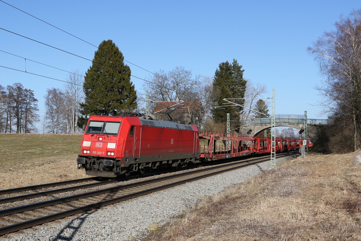 185 203 mit einem leeren Autozug aus Freilassing kommend am 8. M�rz 2022 bei �bersee.
