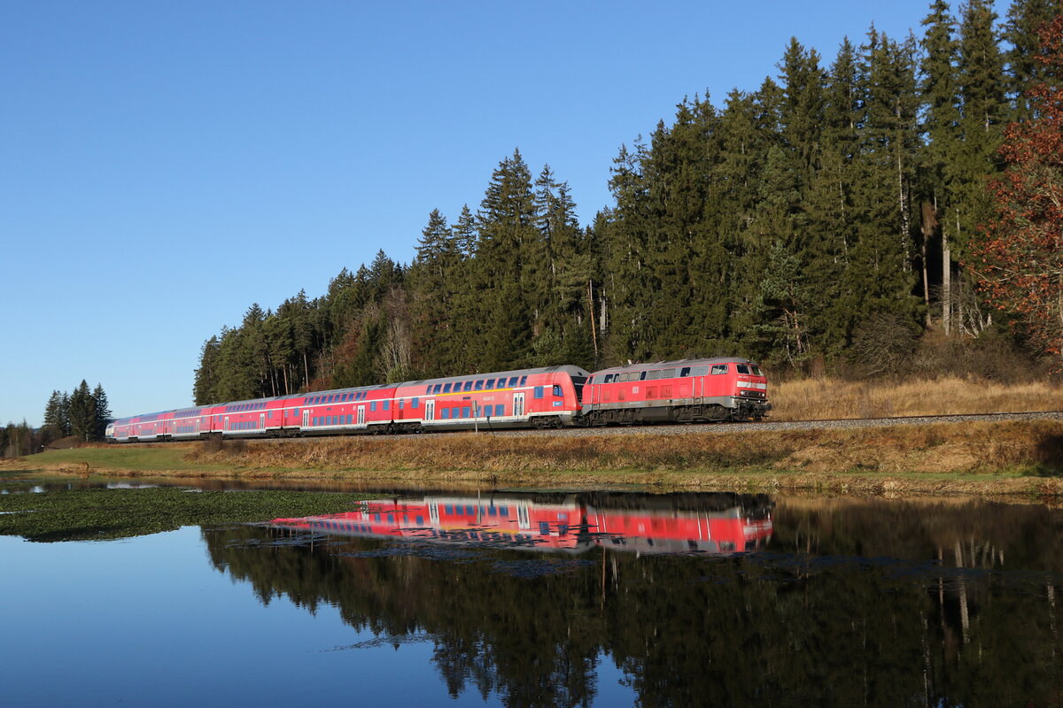 218 411 war am 21. November 2021 mit einem Doppelstock-Regionalzug bei Ruderatshofen in Richtung M�nchen unterwegs.